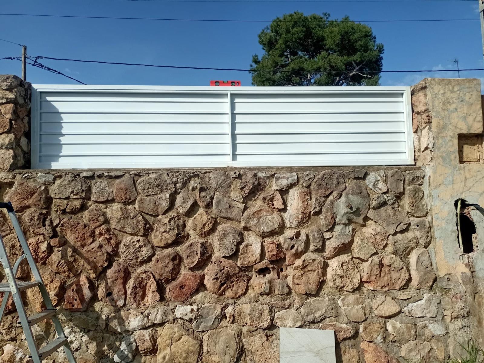 panel de lamas blanco instalado sobre muro de mampostería